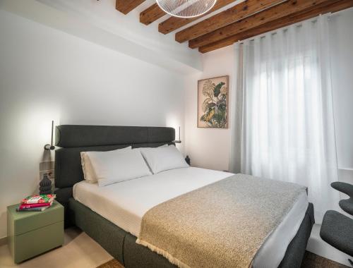 a bedroom with a large bed and a window at Palazzo Degli Eletti R&R in Venice