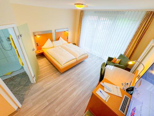 a hotel room with a bed and a desk at Hotel Birkenhof in Hanau am Main