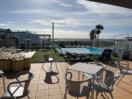 a patio with chairs and a table and a pool at Rainha Juliana in Fuzeta