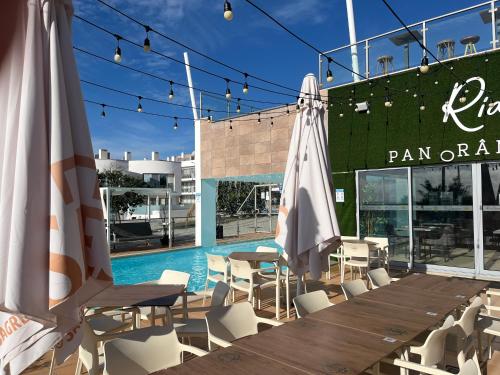a pool with a table and chairs and an umbrella at Rainha Juliana in Fuzeta