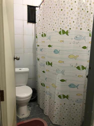 a bathroom with a toilet and a shower curtain with fishes at Den Nest Hostel KRABI in Krabi