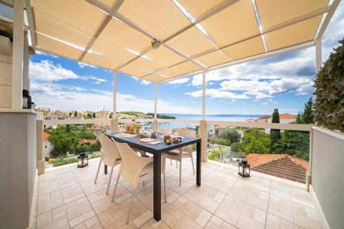 a dining room with a table and chairs on a balcony at Apartment Darka 1 in Sumartin