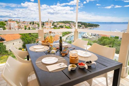 a table with food and wine on top of a balcony at Apartment Darka 1 in Sumartin