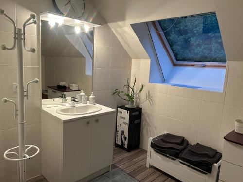 a white bathroom with a sink and a window at Chez Mamie in Hautot-sur-Mer