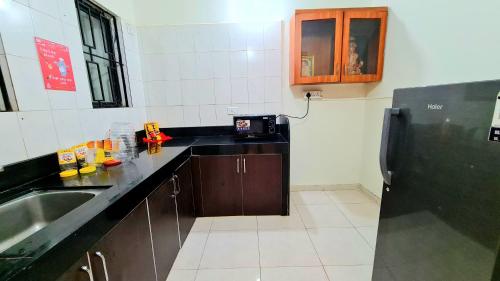 una cucina con lavandino e piano di lavoro nero di Elephant House - Boutique Hostel & CoWork a Méribel Village