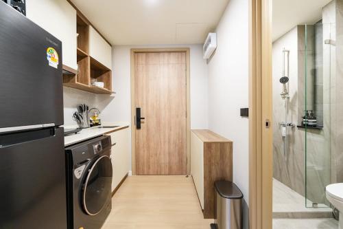 une cuisine avec une laveuse et une sécheuse à côté d'une porte dans l'établissement Space Cherngtalay 323, à Ban Thalat Choeng Thale