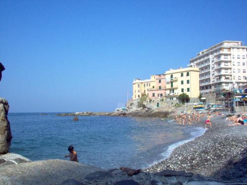 uma praia com pessoas na água e edifícios em Casa al mare con parcheggio em Génova