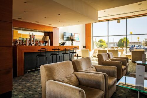 a lobby with chairs and a bar in a building at VIP Executive Santa Iria Hotel in Santa Iria da Azóia