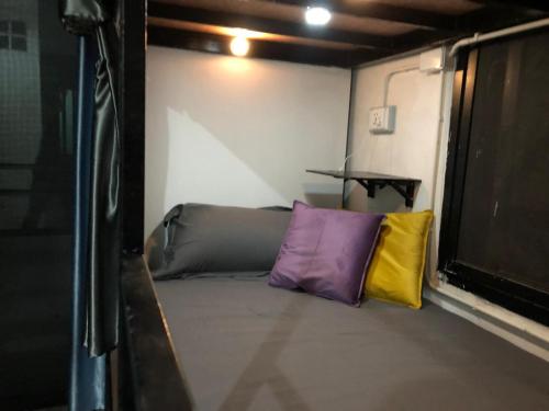 a small room with two colorful pillows in it at Den Nest Hostel KRABI in Krabi