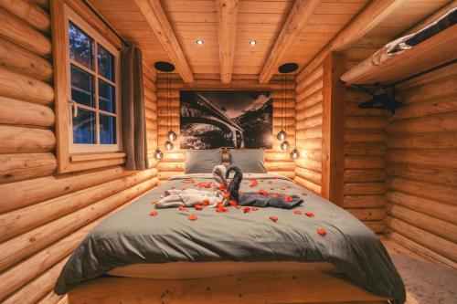 un enfant allongé sur un lit dans une cabane en rondins dans l'établissement Cosy Cottage w/ Jacuzzi in Amazing Region, à Aywaille
