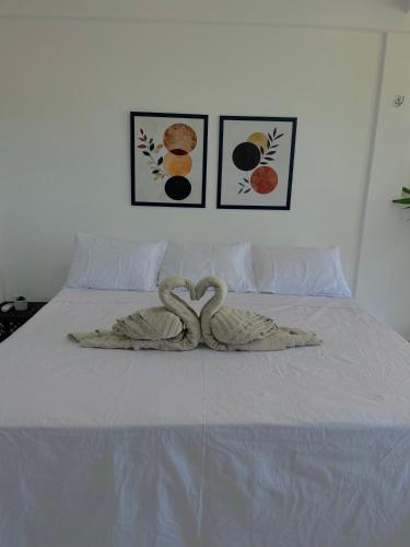 two swans are sitting on top of a bed at Orla Pousada & Café in Parnamirim
