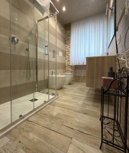 ein Badezimmer mit Glasdusche und Badewanne in der Unterkunft Le Manzé in Torre Maggiore