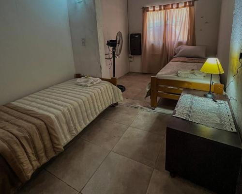 ビジャ・ヘネラル・ベルグラーノにあるPequeño chalet con frente al arroyoのベッドルーム1室(ベッド2台、ランプ付きテーブル付)