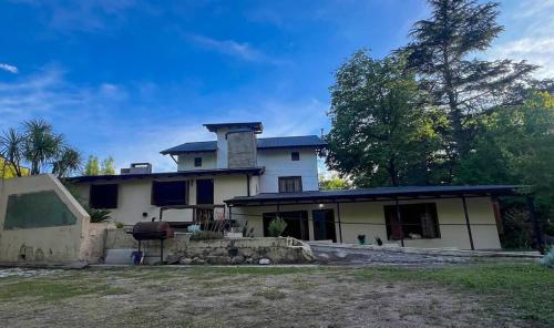 ビジャ・ヘネラル・ベルグラーノにあるPequeño chalet con frente al arroyoの上に煙突がある大きな白い家