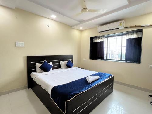 Un dormitorio con una cama grande con almohadas azules. en Hotel 31 Manor, en Nagpur