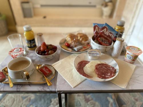 a table topped with plates of food and a cup of coffee at Spend this night in Venice whilst visiting Swansea in Swansea