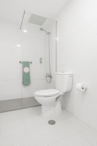 a white bathroom with a toilet and a shower at Apartamentos las Góndolas in Playa del Ingles
