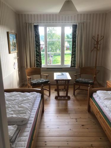 a room with two beds and a table and chairs at STF Vandrarhem Edsbyn in Edsbyn