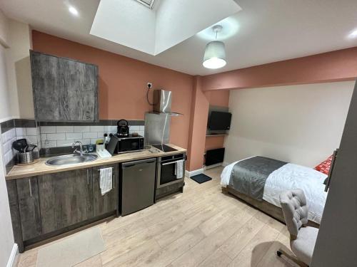 a kitchen with a sink and a bed in a room at Modern Studio Bolton ,Free Parking, Fast WiFi, Ideal for Contractors & Long Stays in Bolton
