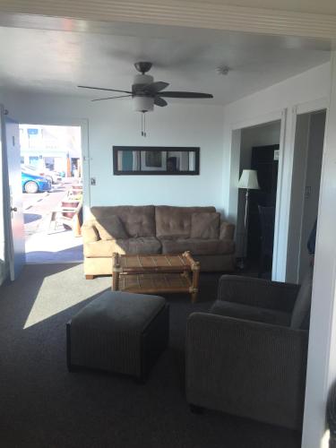 a living room with a couch and a ceiling fan at Dolphin Cove Motel in Pismo Beach