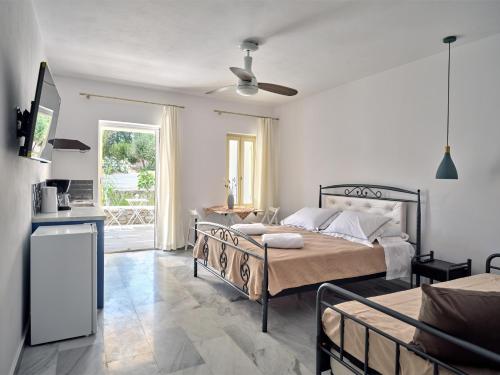 a bedroom with two beds and a ceiling fan at Villa Maria Naoussa in Naousa