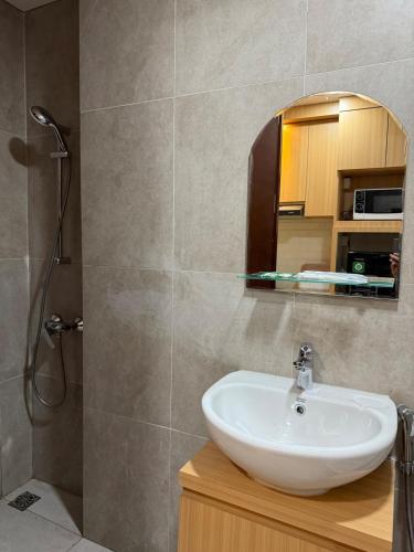 Un baño con lavabo y ducha en Modern 1BR with City & Sea View, en Batam Centre
