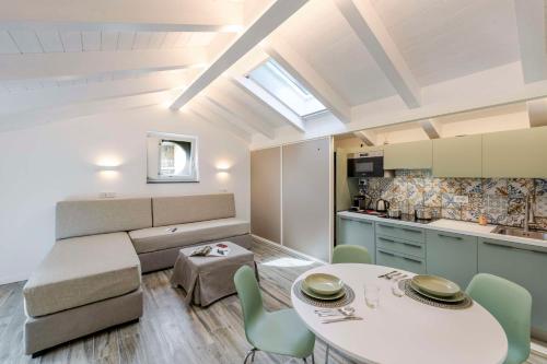 a kitchen and a living room with a table and chairs at Agave Apartment in Vico Equense