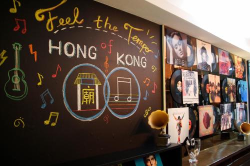 Una pared negra con dibujos musicales. en Tempo Inn@ David Mansion, en Hong Kong