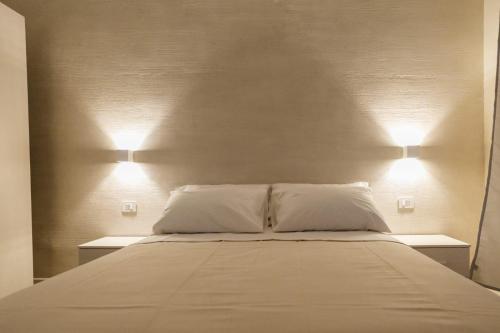 a bed with two white pillows and two lights on it at IL CENTRO rooms in Cerignola