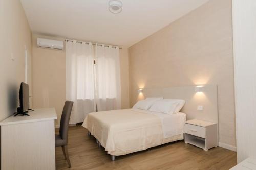 a bedroom with a bed and a desk and a television at IL CENTRO rooms in Cerignola