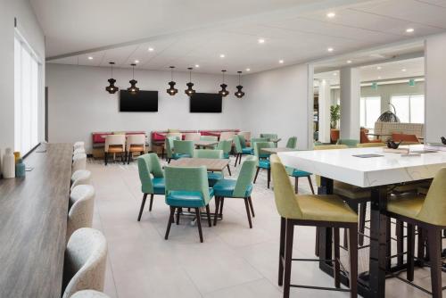a restaurant with tables and chairs and a bar at Home2 Suites By Hilton Cleveland, TN in Cleveland