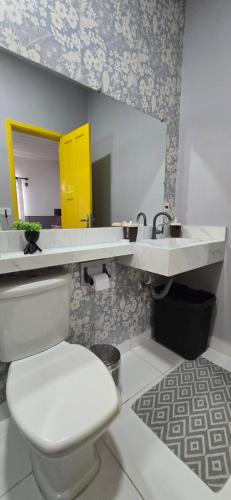 a bathroom with a white toilet and a sink at Mecejana Home in Boa Vista