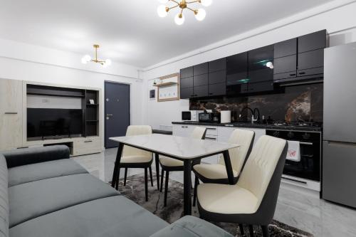 a kitchen and living room with a table and chairs at Urban Retreat 1BDR Craiova in Bordeiu