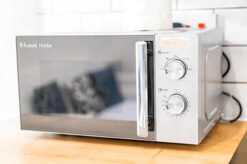 a microwave oven sitting on top of a counter at Modern Apartment - Wolverhampton Centre - Fast WiFi - Netflix 12AC in Wolverhampton