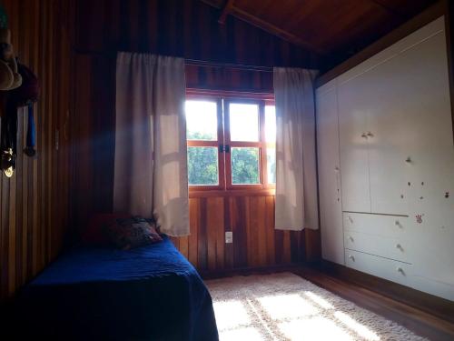 a bedroom with a blue bed and a window at Casa de Campo in Caldas