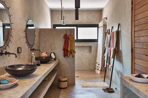 a bathroom with two sinks and two mirrors at Yokan Lodge in Palmarin