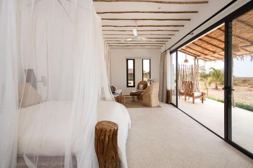 a bedroom with a bed with a mosquito net at Yokan Lodge in Palmarin