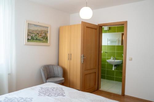 Old Town Piešťany Apartments في بييشتِني: غرفة نوم مع خزانة وحمام مع حوض