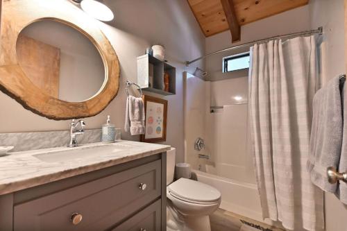 ein Badezimmer mit Waschbecken, Toilette und Spiegel in der Unterkunft Cozy Chic Chalet - Enchanting & Fun Family Retreat - Hot Tub & Fire Pit - Dog Friendly in Dorrington