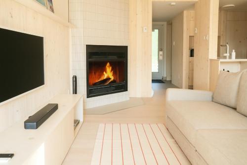 ein Wohnzimmer mit Kamin und Sofa in der Unterkunft Volume Nord - Loft de montagne in Stoneham