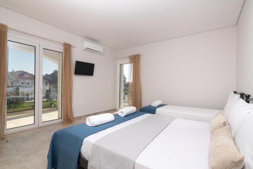 チィリヴィにあるThe Serene Retreatのベッドと大きな窓のある白い寝室