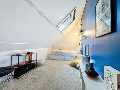 ein Dachzimmer mit einem Bett und einer blauen Wand in der Unterkunft pleasant old and comfortable little house in Apremont