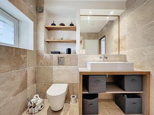 ein Badezimmer mit Toilette, Waschbecken und Spiegel in der Unterkunft pleasant old and comfortable little house in Apremont