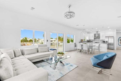 a white living room with a white couch and blue chairs at Surfstream Edge in Marathon Airport