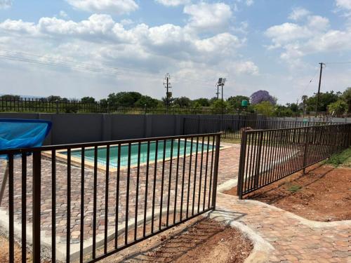 a metal fence around a swimming pool in a park at GlowtiAirbnb in Centurion