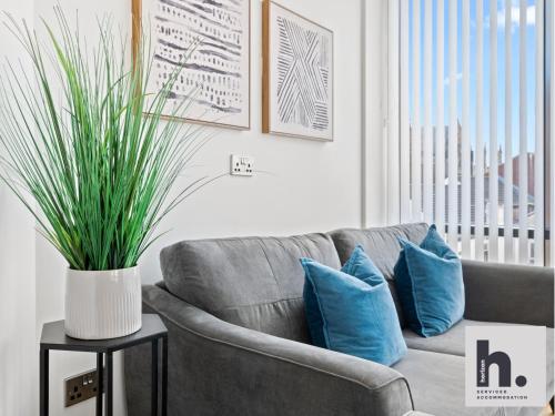 a living room with a gray couch with blue pillows at Contractors - Long Stay - City Centre - Free Parking - Balcony in Hull