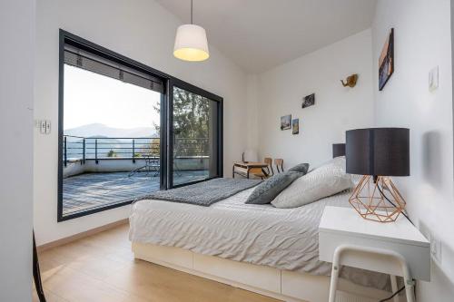 a bedroom with a bed and a large window at Villa calme avec vue 4 à 8 personnes - salle de sport in Saint-Amarin