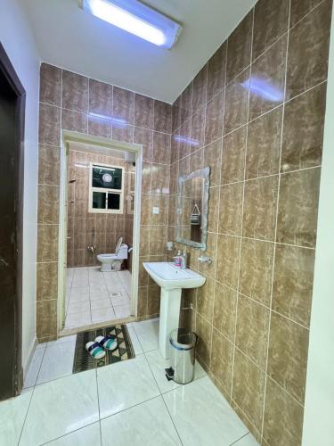 a bathroom with a sink and a shower at شقق طرابزون المخدومة in Rumāḩ