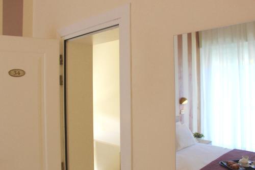 uno specchio in una camera da letto accanto a un letto di King Hotel a Cesenatico