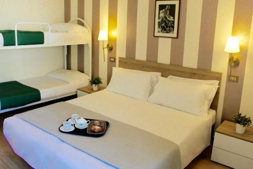 una camera da letto con un letto con un vassoio di cibo sopra di King Hotel a Cesenatico